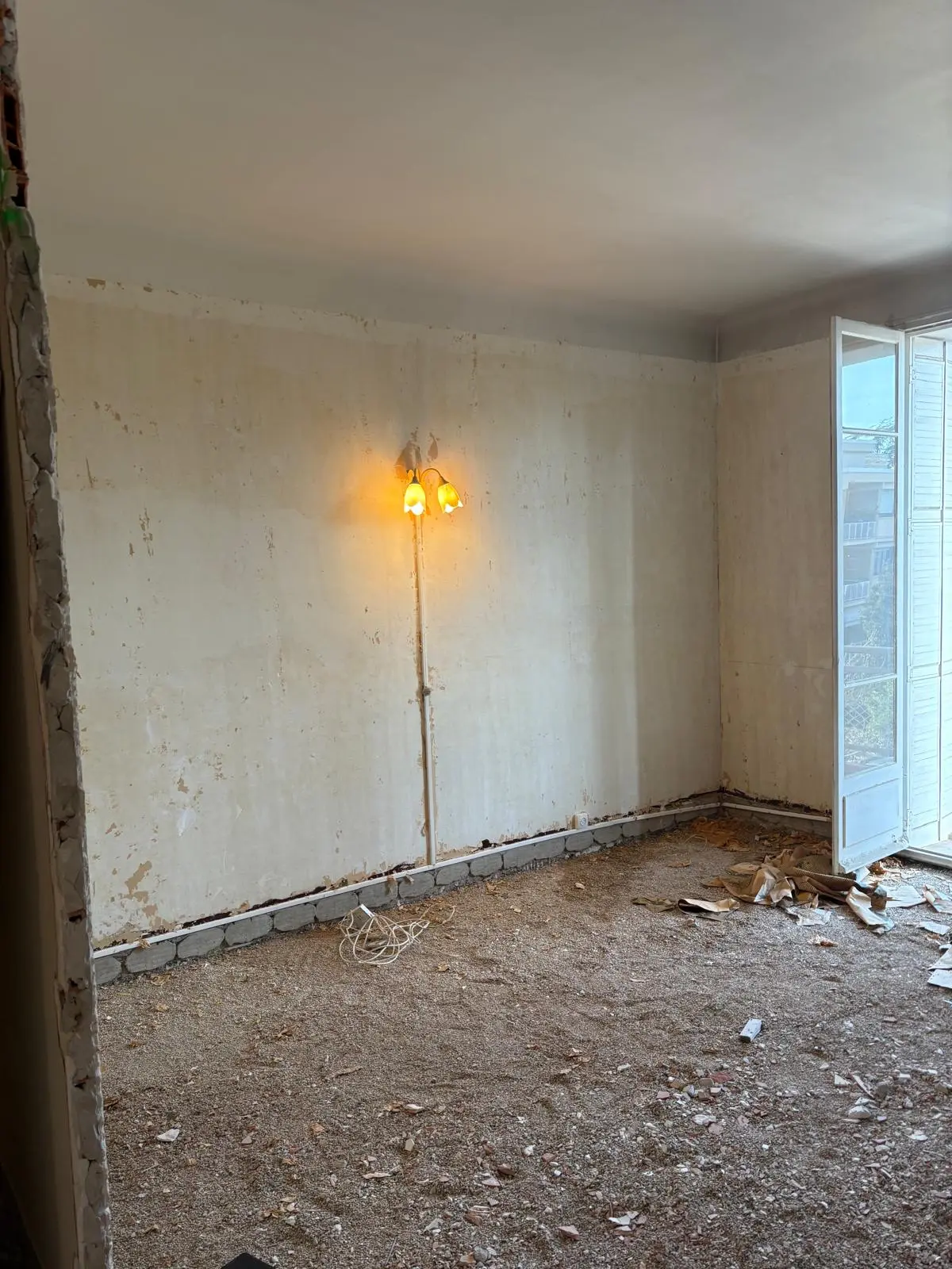 Chambre en démolition avec ancien papier peint et sol décapé - rénovation appartement ancien Aix