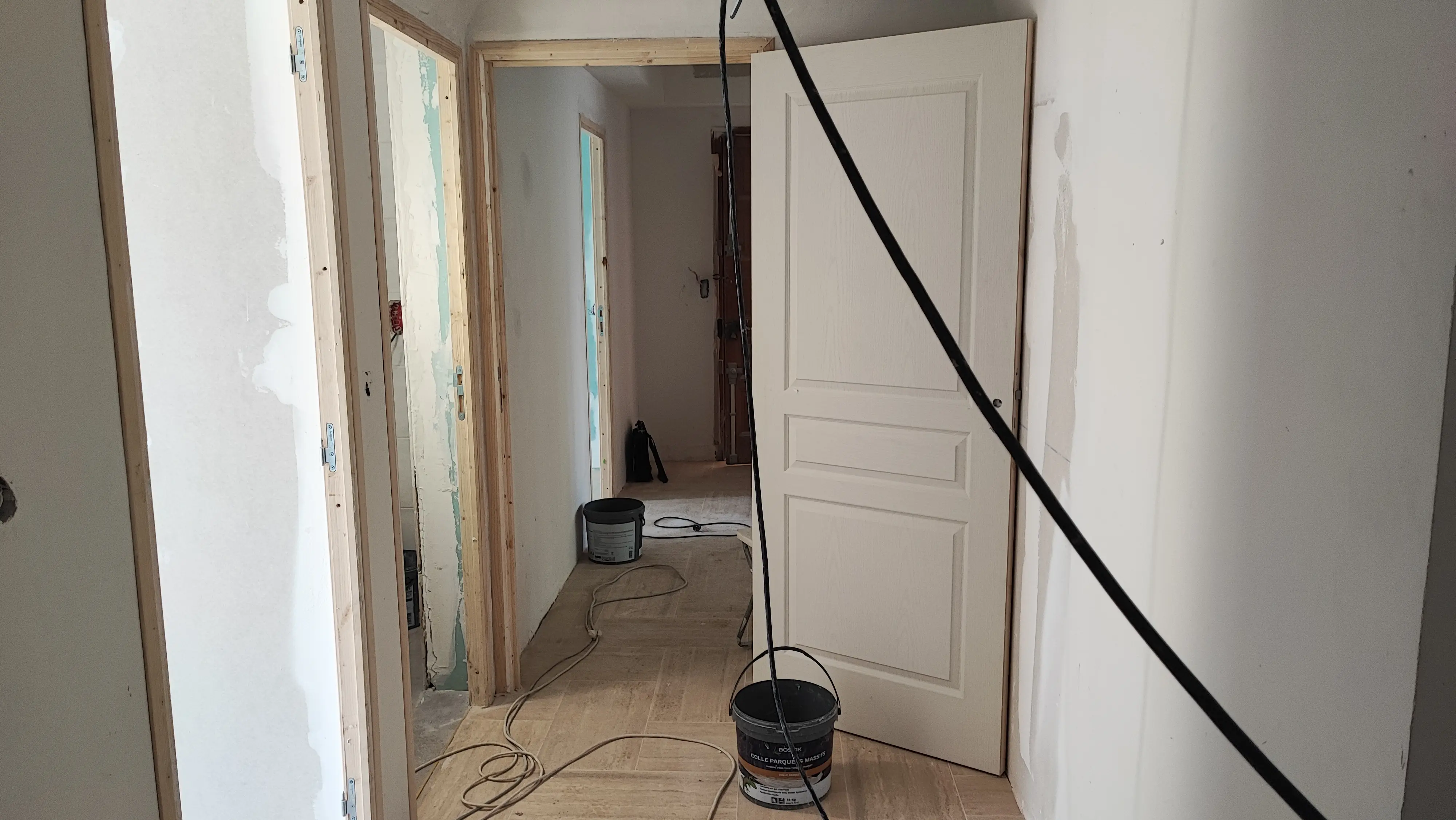 Couloir avec nouvelles portes intérieures moulurées en cours de pose - rénovation appartement Aix