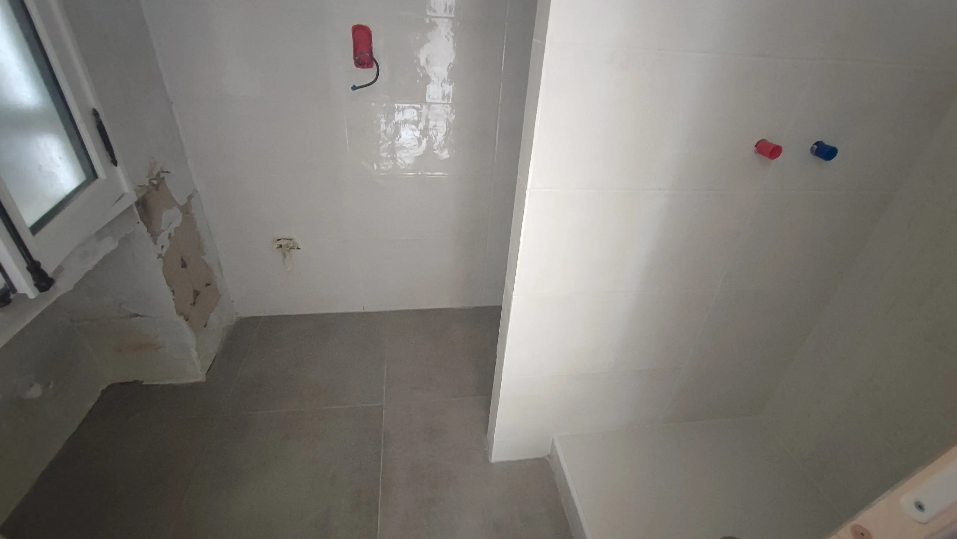 Salle d'eau en cours de carrelage avec grands carreaux gris et faïence blanche - salle de bain Aix-en-Provence