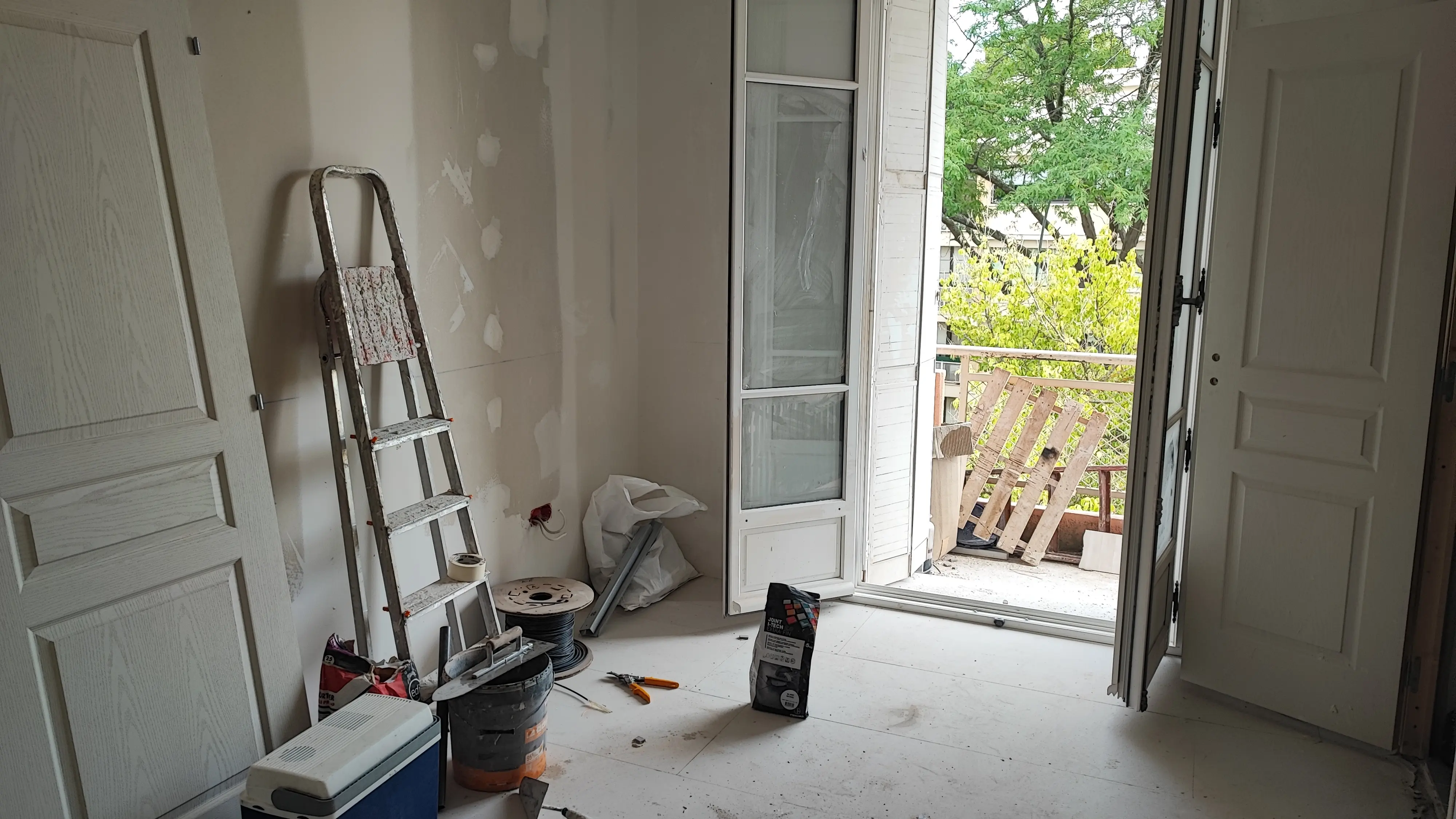 Pièce avec portes neuves en attente de pose et matériel de peinture - finitions appartement Aix-en-Provence