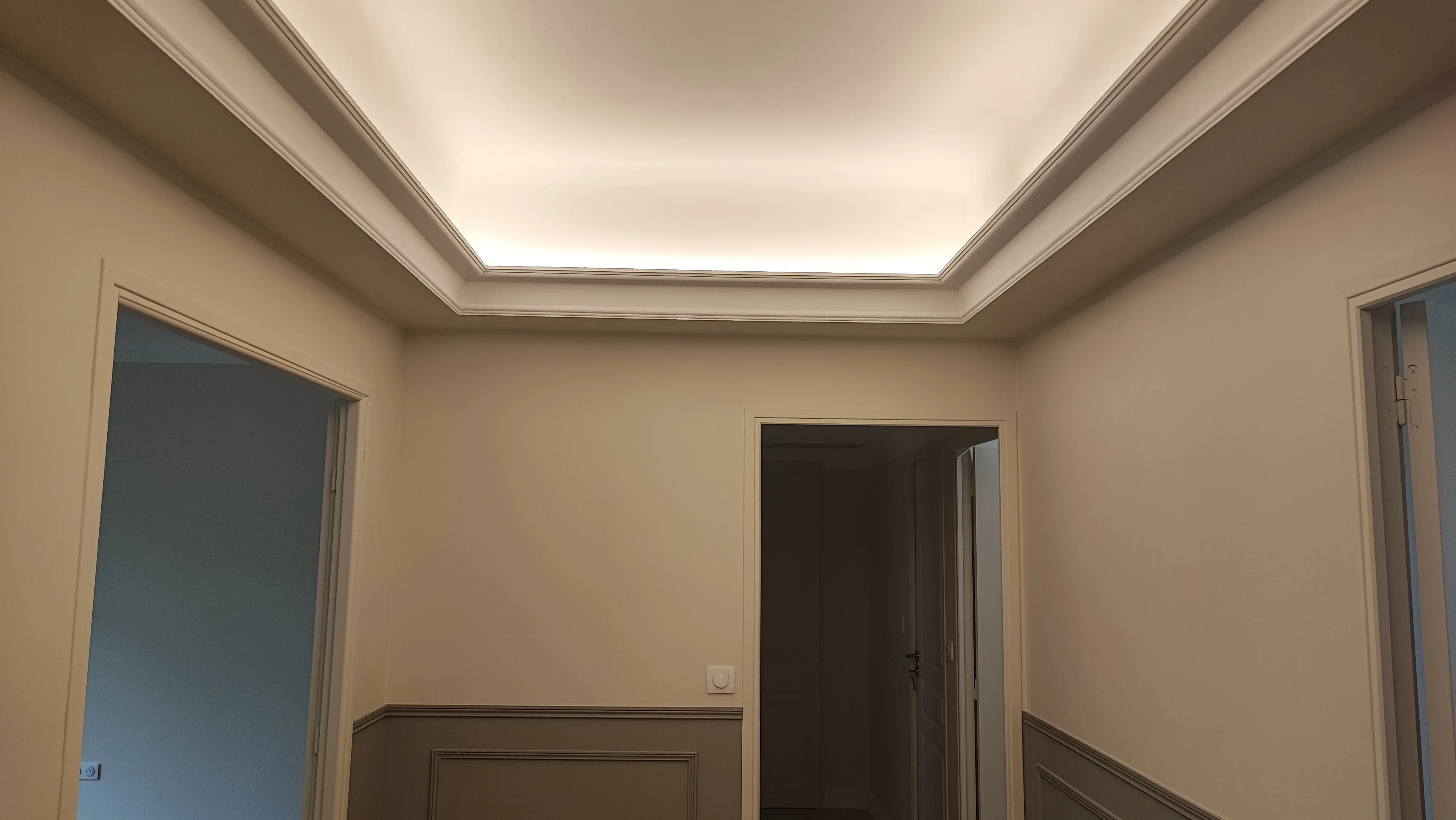 Entrée rénovée avec faux plafond à éclairage indirect et soubassements moulurés - rénovation Aix-en-Provence
