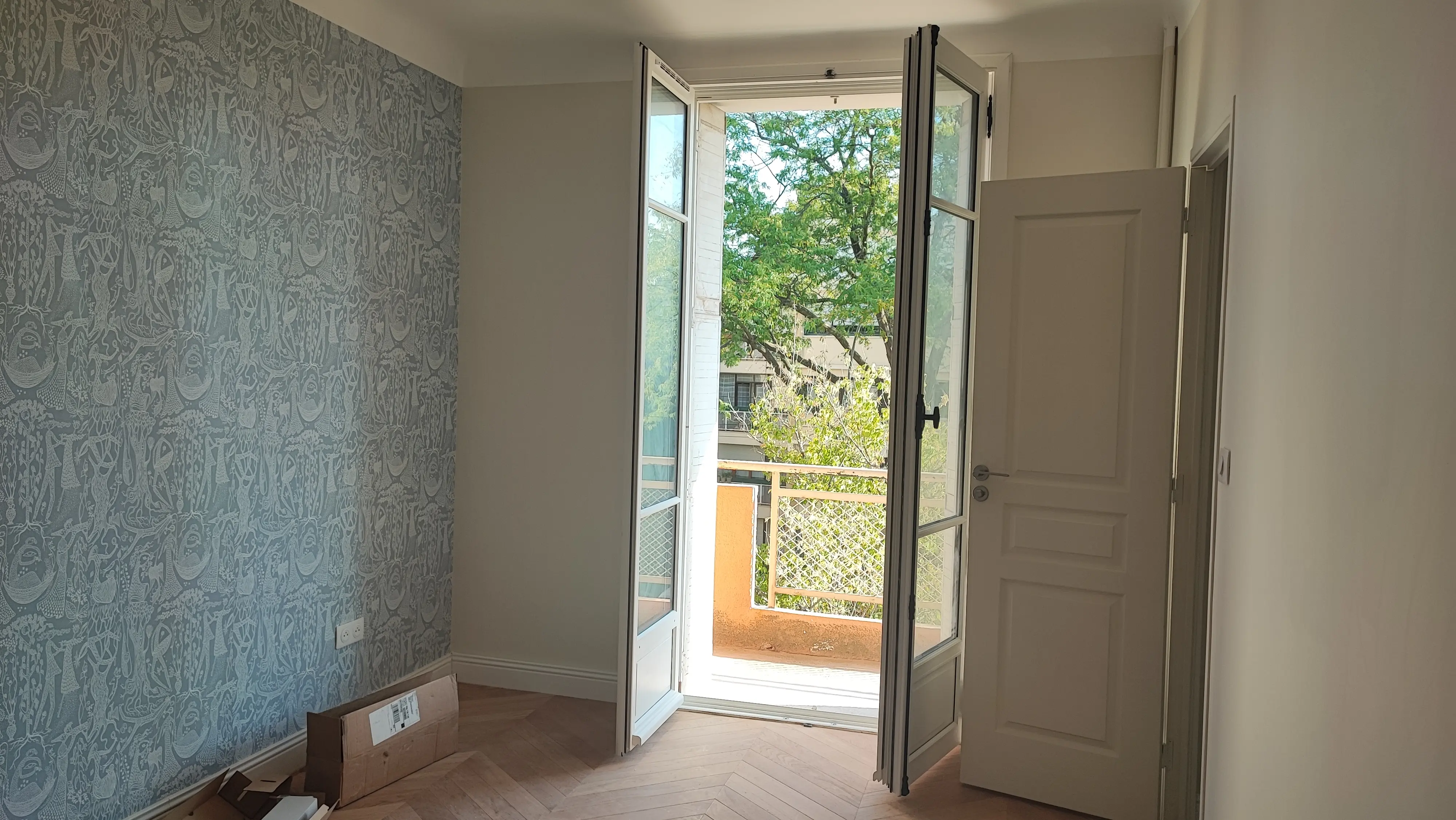 Chambre avec papier peint vert à motifs et porte-fenêtre sur balcon - rénovation appartement Aix