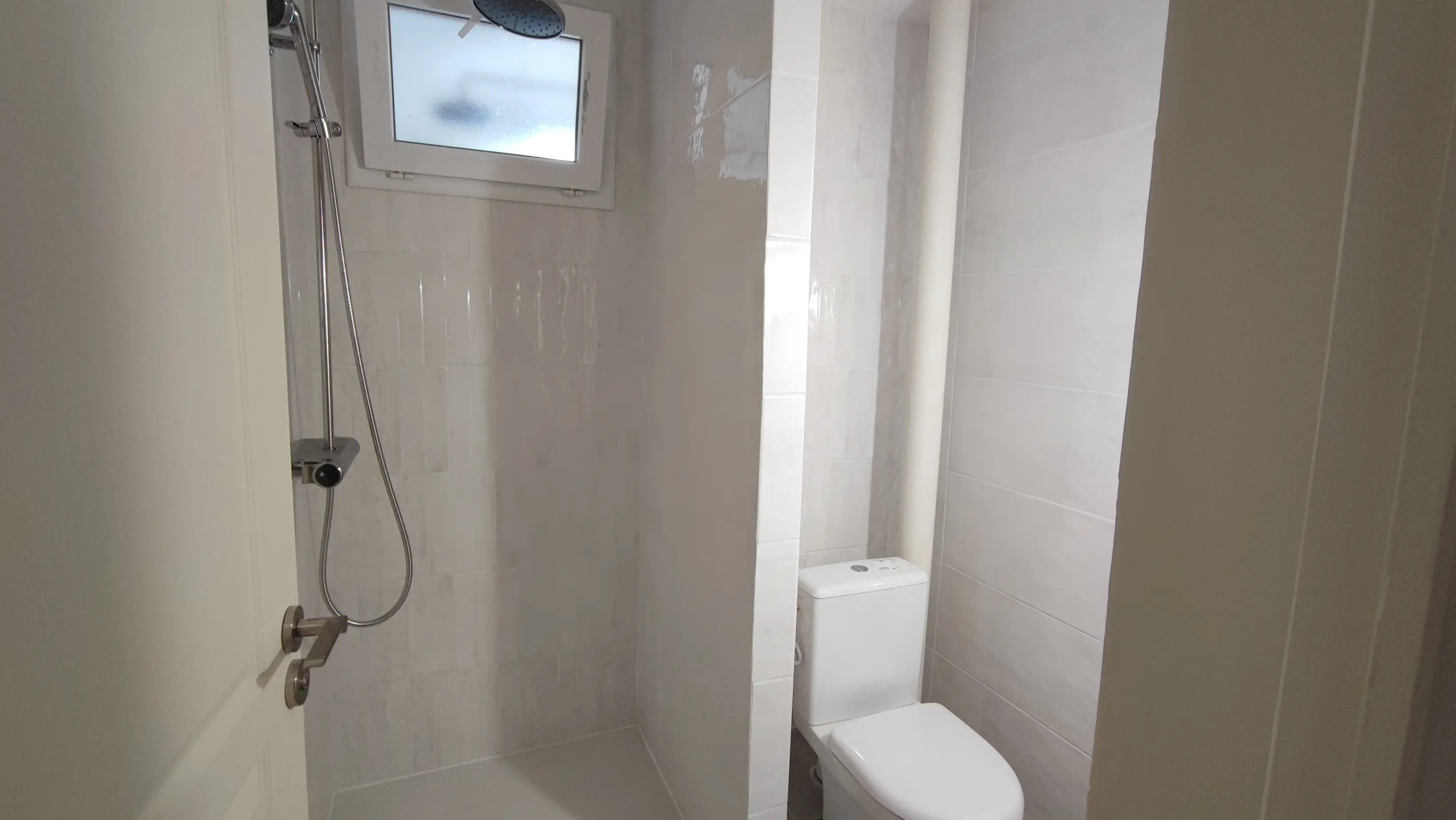 Salle d'eau rénovée avec douche, faïence blanche et WC - rénovation salle d'eau Aix-en-Provence