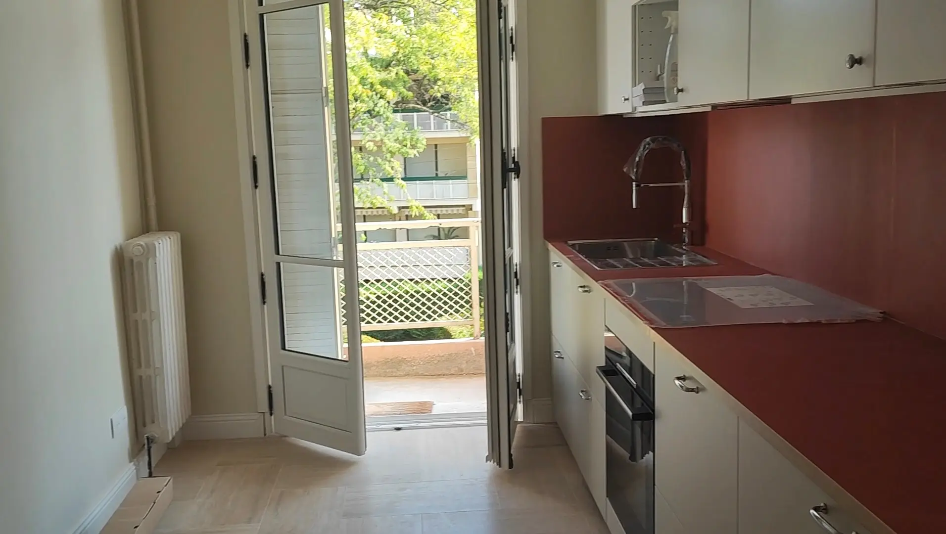 Cuisine équipée en longueur avec plan de travail et crédence rouge - rénovation cuisine Aix-en-Provence