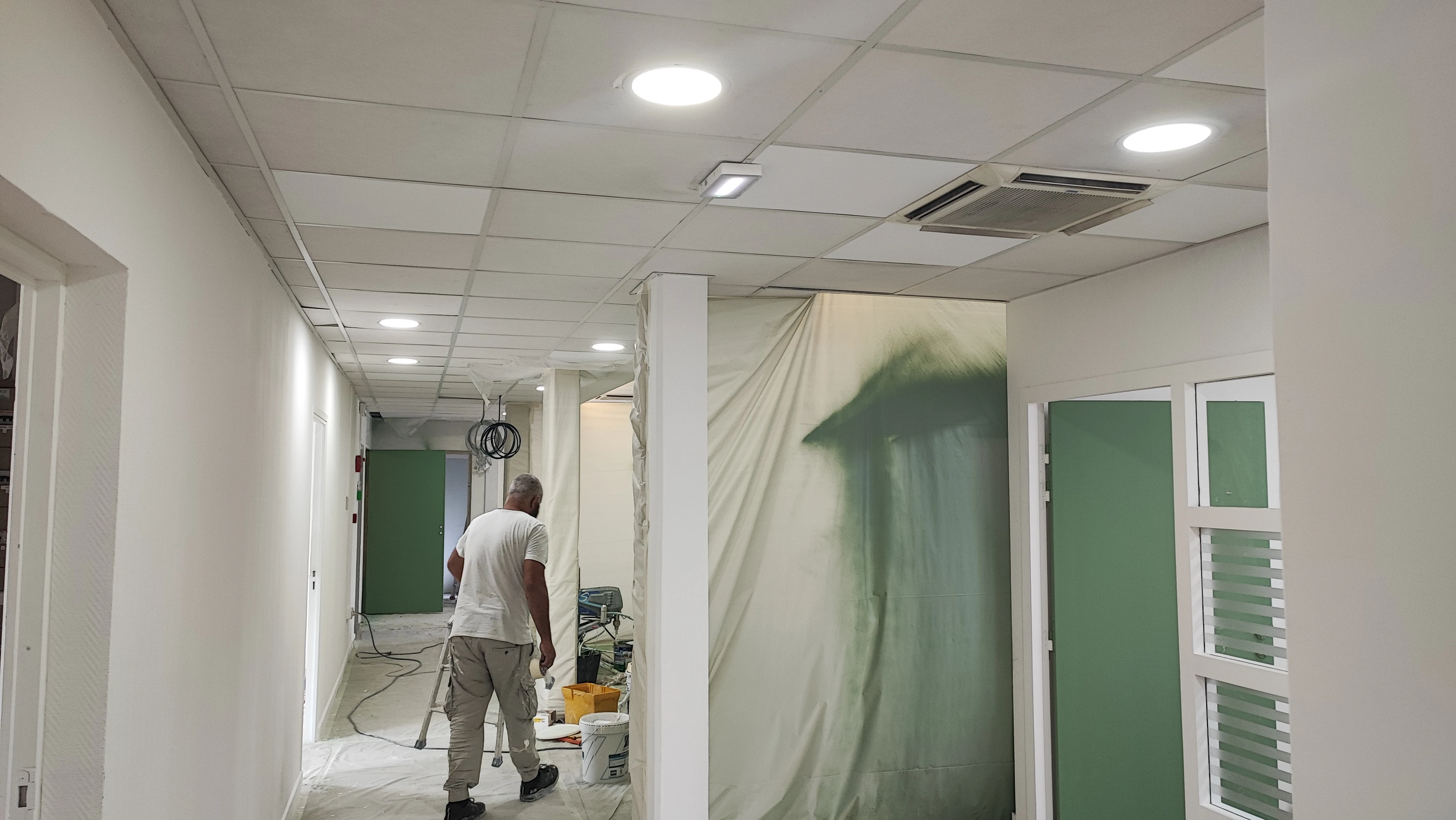 Peintre ACR Provence dans un couloir bâché pendant les travaux de bureaux