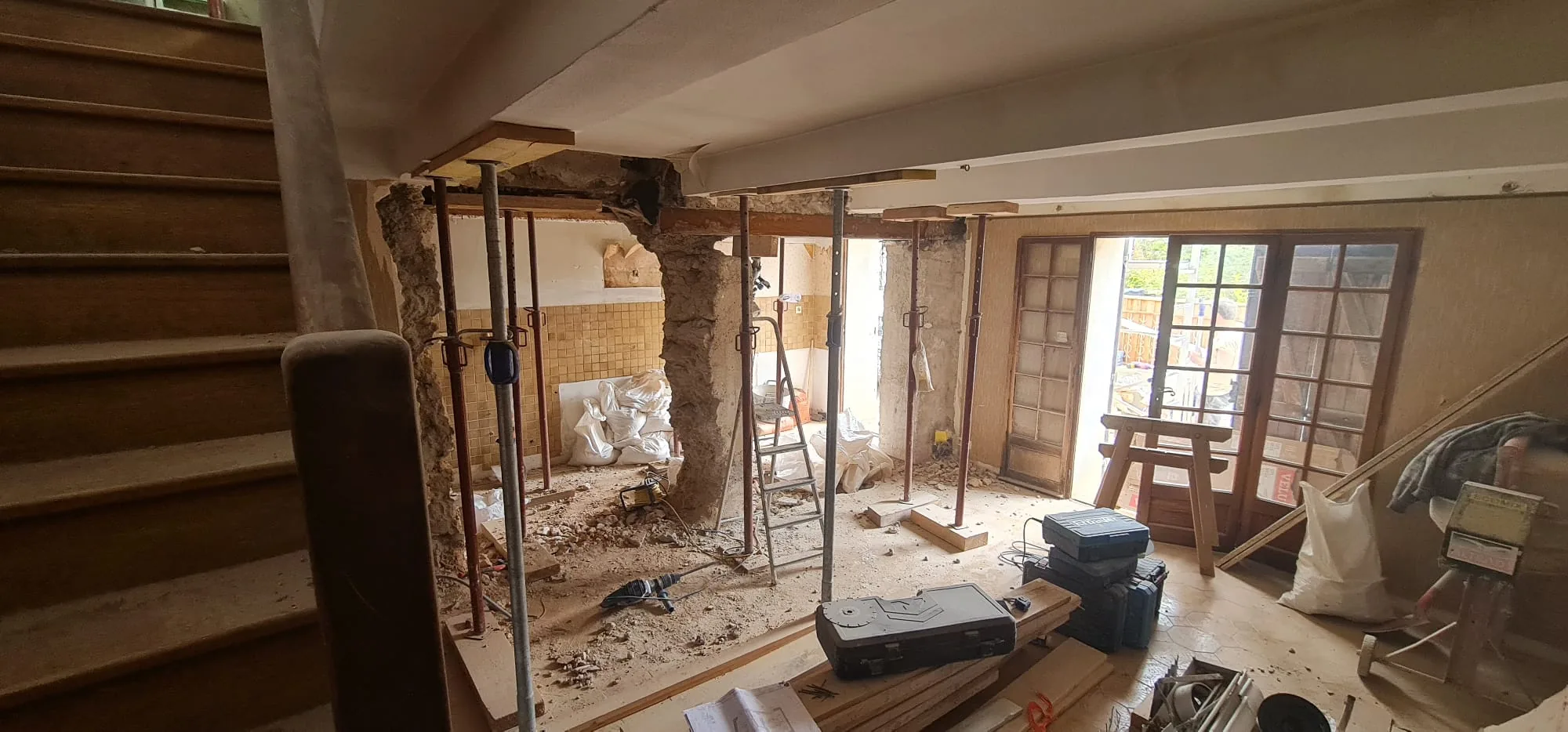 Étaiement et reprise de charge sur mur en pierre sous un escalier en bois