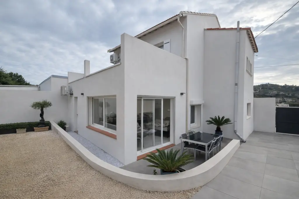 Façade rénovée avec enduit blanc et nouvel aménagement extérieur